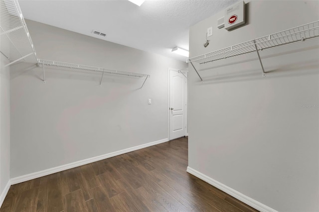 spacious closet featuring visible vents and wood finished floors