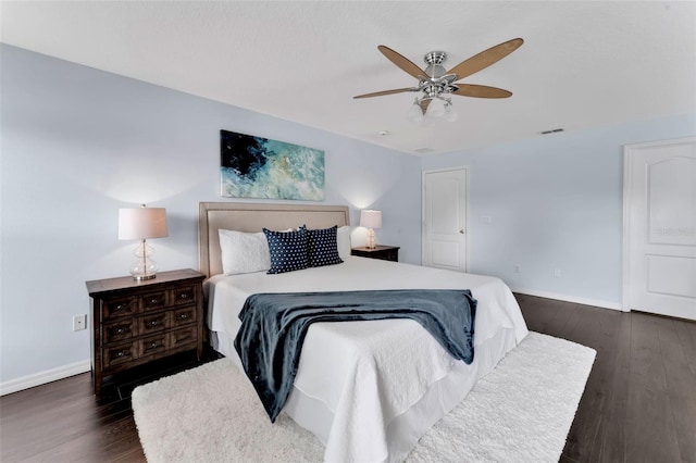 bedroom with dark wood finished floors, visible vents, and baseboards