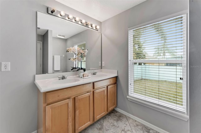 bathroom featuring double vanity, baseboards, and a sink