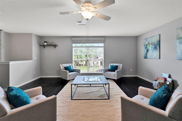 living room with baseboards, a textured ceiling, and dark wood-style flooring