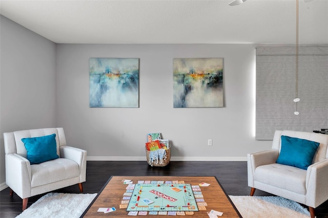 living area with baseboards and wood finished floors