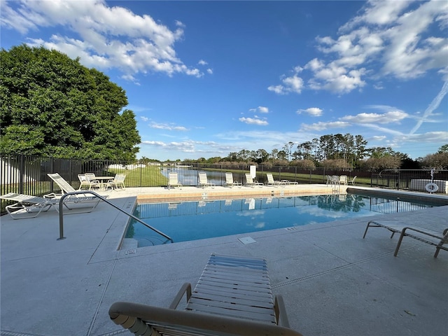 community pool with a patio and fence