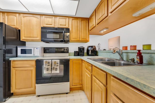 kitchen with black appliances, light floors, light countertops, and a sink