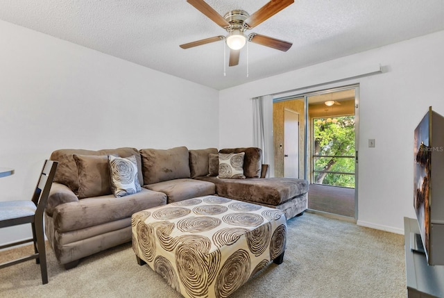 living area featuring a textured ceiling, a ceiling fan, baseboards, and light carpet