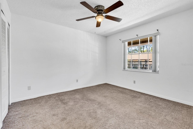 unfurnished room with baseboards, carpet floors, and a textured ceiling