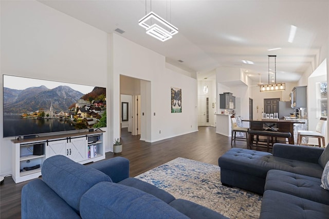 living room featuring dark wood-style floors, visible vents, baseboards, and lofted ceiling