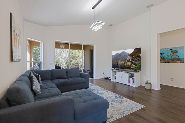 living area featuring visible vents, baseboards, dark wood-style flooring, and vaulted ceiling