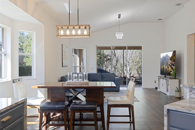 dining area with visible vents, dark wood-style flooring, and vaulted ceiling