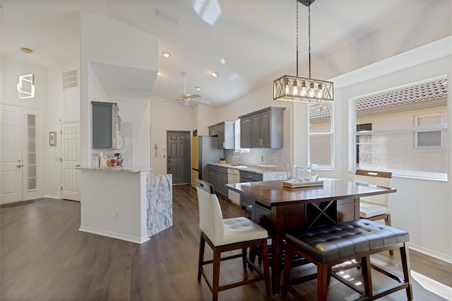 dining room featuring visible vents, ceiling fan, baseboards, dark wood-style floors, and high vaulted ceiling