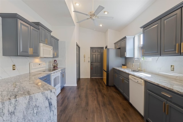 kitchen featuring a sink, dark wood-style floors, white appliances, light stone countertops, and ceiling fan