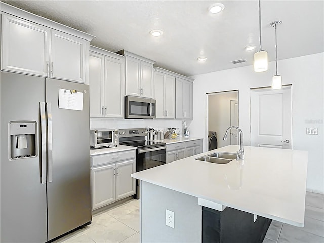 kitchen with visible vents, an island with sink, light countertops, stainless steel appliances, and a sink