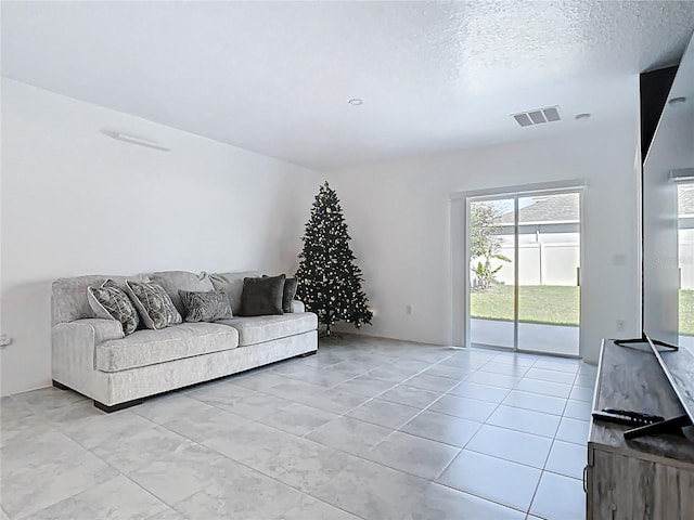 living area with visible vents and a textured ceiling