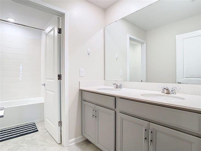 full bath featuring a sink, baseboards, and double vanity