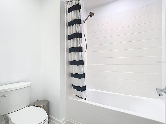 bathroom featuring baseboards, toilet, and shower / tub combo