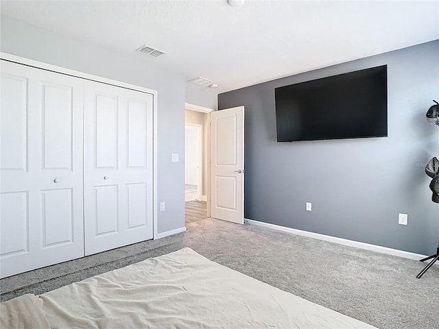 unfurnished bedroom featuring a closet, visible vents, baseboards, and carpet