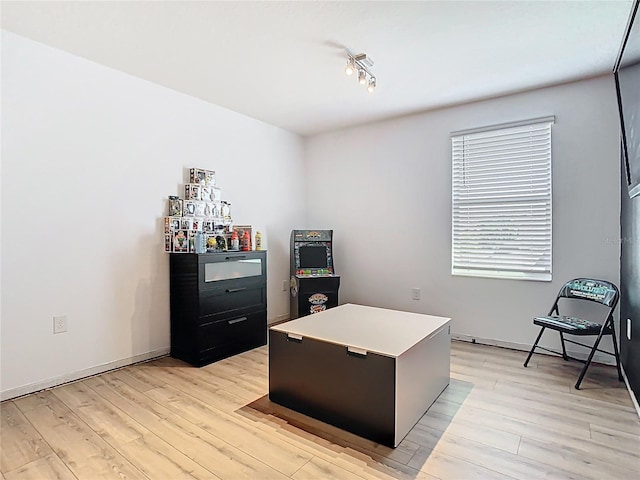 office area featuring baseboards and light wood finished floors