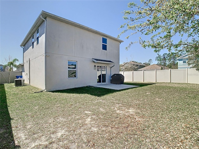 back of property with central AC unit, a lawn, stucco siding, a fenced backyard, and a patio area