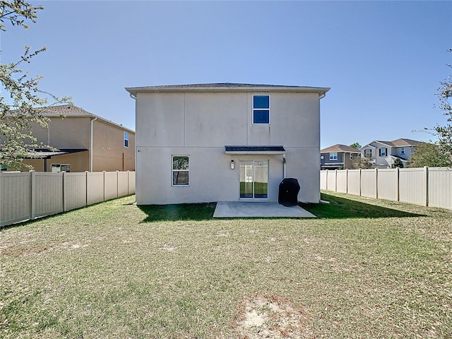 rear view of property featuring a yard, a patio, a fenced backyard, and stucco siding