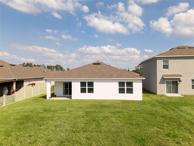 rear view of house featuring a yard, a patio area, a fenced backyard, and stucco siding