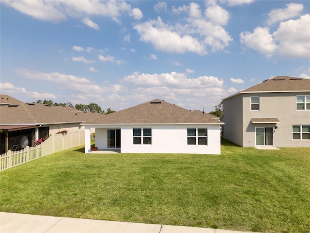 rear view of property featuring a fenced backyard, stucco siding, and a yard