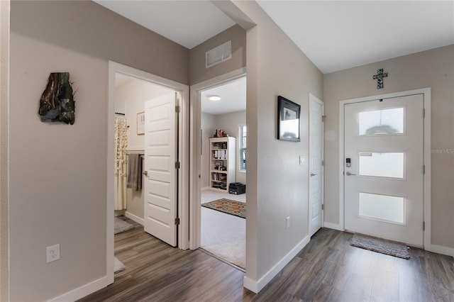 foyer with visible vents, baseboards, and wood finished floors