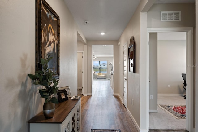 corridor featuring dark wood-style floors, baseboards, and visible vents