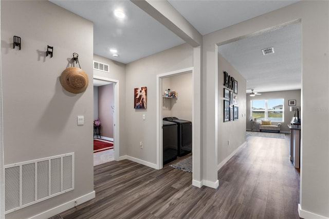 hall featuring visible vents, independent washer and dryer, and wood finished floors