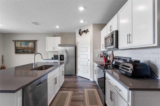 kitchen with dark countertops, visible vents, stainless steel appliances, and a sink