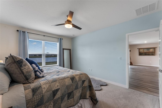 bedroom with visible vents, baseboards, carpet, and a ceiling fan