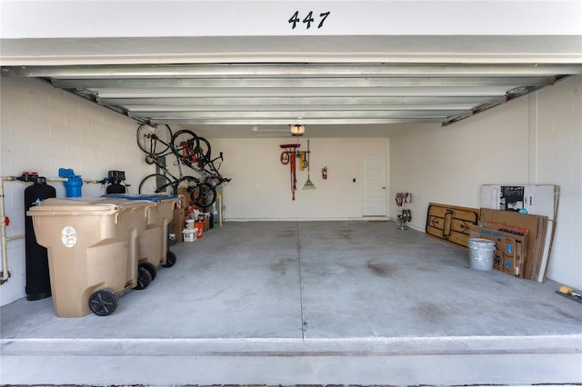 garage featuring concrete block wall and a garage door opener