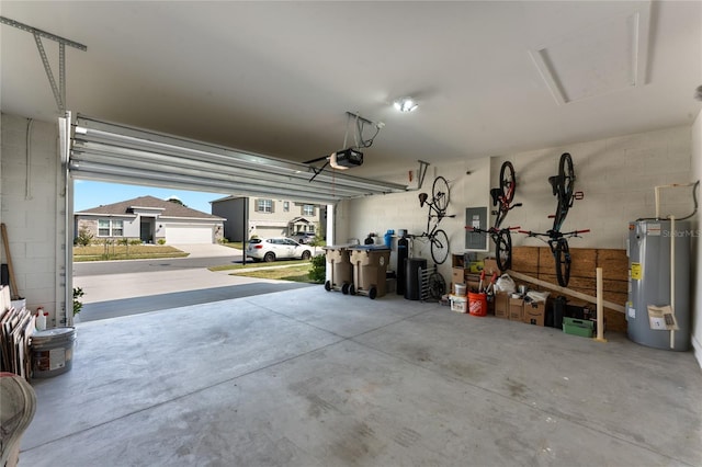 garage featuring electric panel, concrete block wall, electric water heater, and a garage door opener