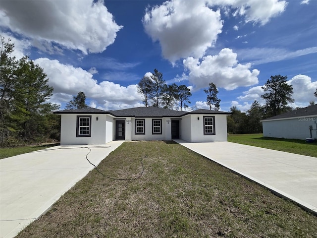 view of front of home featuring a front yard, concrete driveway, and stucco siding