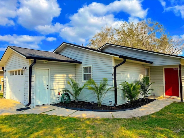 view of side of property featuring a lawn and a garage