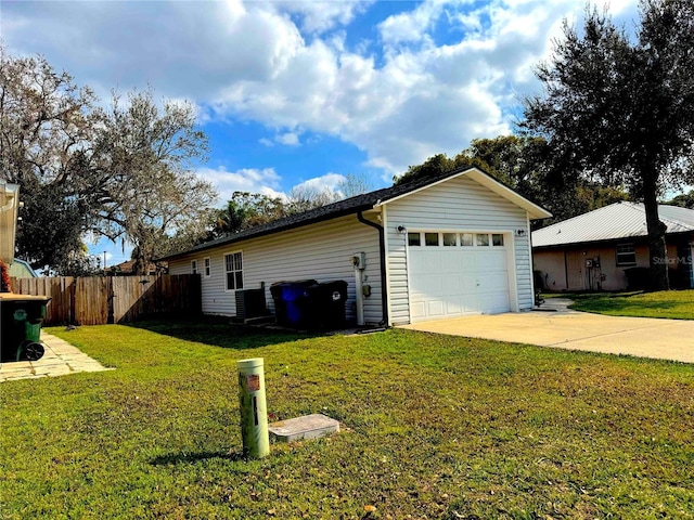 view of property exterior with an attached garage, a lawn, fence, and driveway