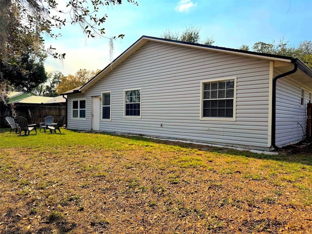 back of house featuring a yard and fence