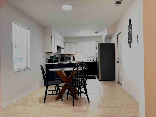 dining space featuring light tile patterned floors, baseboards, and visible vents