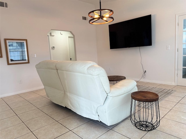 living room featuring visible vents, arched walkways, baseboards, and light tile patterned flooring