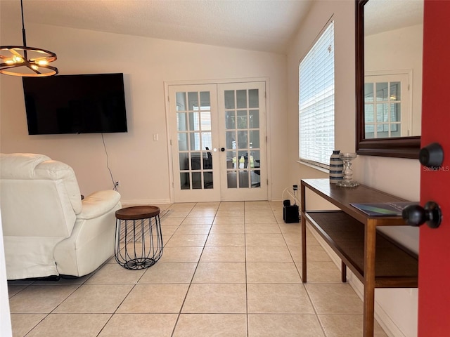 interior space with lofted ceiling, light tile patterned floors, french doors, and a textured ceiling