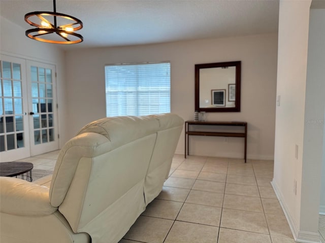 living room with light tile patterned floors, french doors, baseboards, and a chandelier