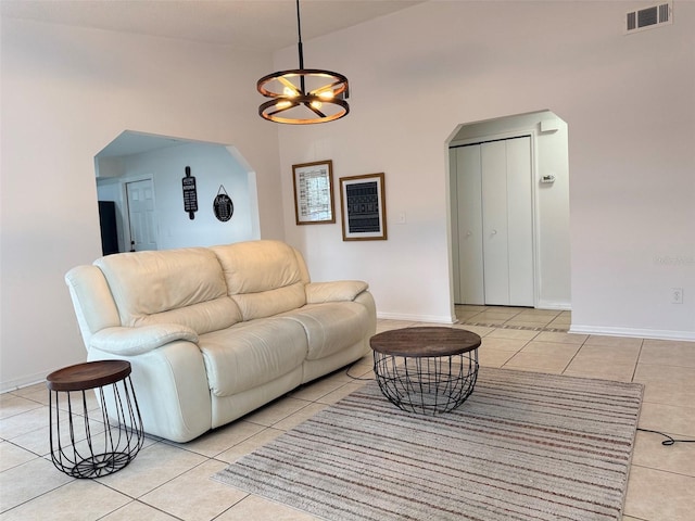 living room with light tile patterned flooring, visible vents, and arched walkways