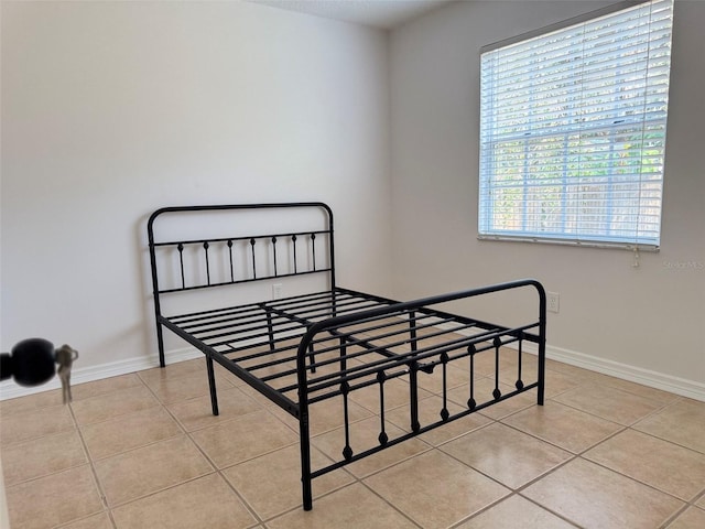 tiled bedroom featuring baseboards