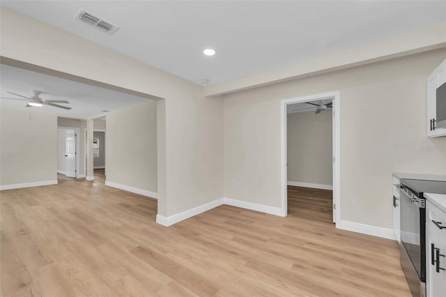 interior space with visible vents, baseboards, ceiling fan, and light wood finished floors