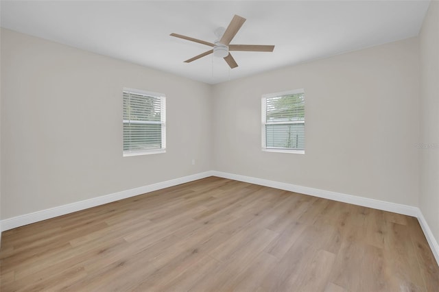 empty room with a ceiling fan, baseboards, and light wood-type flooring