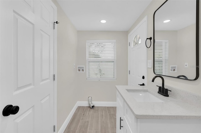 bathroom featuring recessed lighting, baseboards, and vanity