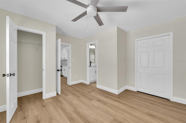 unfurnished bedroom with a closet, baseboards, and light wood-style floors