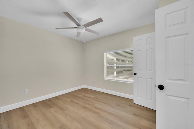 unfurnished room featuring light wood finished floors, baseboards, and a ceiling fan