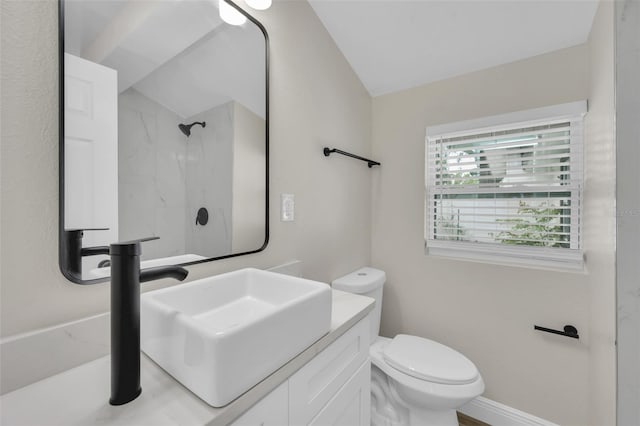 bathroom with vanity, baseboards, vaulted ceiling, a shower, and toilet