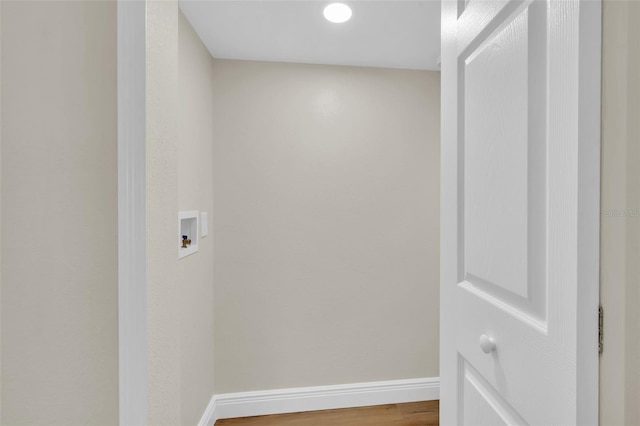 washroom featuring baseboards, washer hookup, wood finished floors, and laundry area