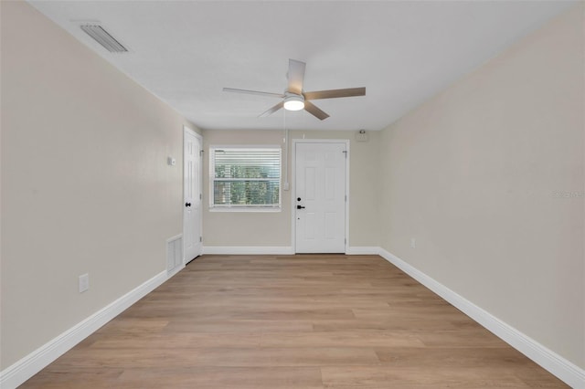 unfurnished room with visible vents, baseboards, light wood-type flooring, and ceiling fan