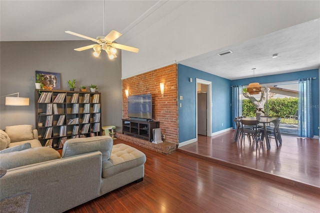 living area with visible vents, lofted ceiling, a ceiling fan, wood finished floors, and baseboards